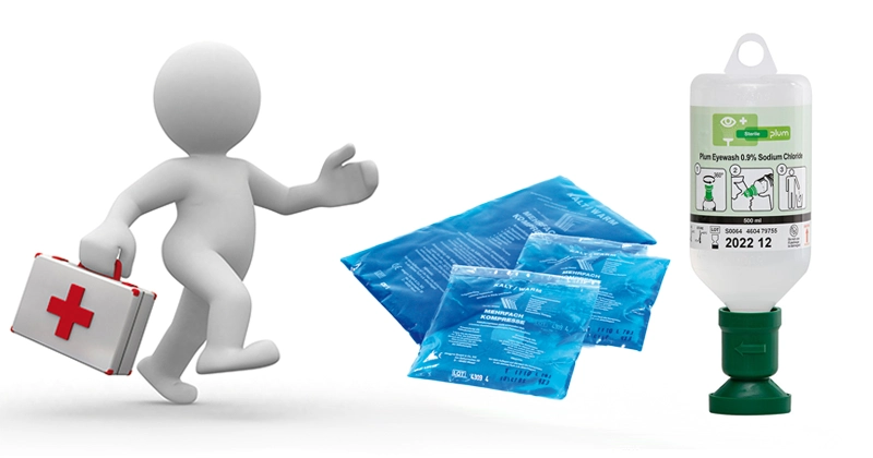 Sortiment an Erste-Hilfe-Produkten, einschließlich Verbandkasten DIN EN, Notfalltasche, Augenspülflaschen, steriler Blutstillung und Einmal-Patientendecken, arrangiert auf einem Tresen.